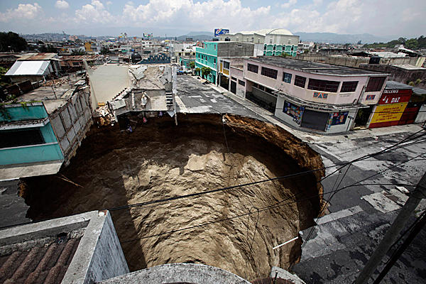 Фотография гигантской воронки в Гватемале, поглотившей перекресток и трёхэтажное здание 30 мая 2010 г