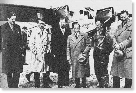 Слева от Гитлера Ганфштенгль. Малорослый человек в центре со шляпой в руке — Рендольф Черчилль, сын лорда Уинстона