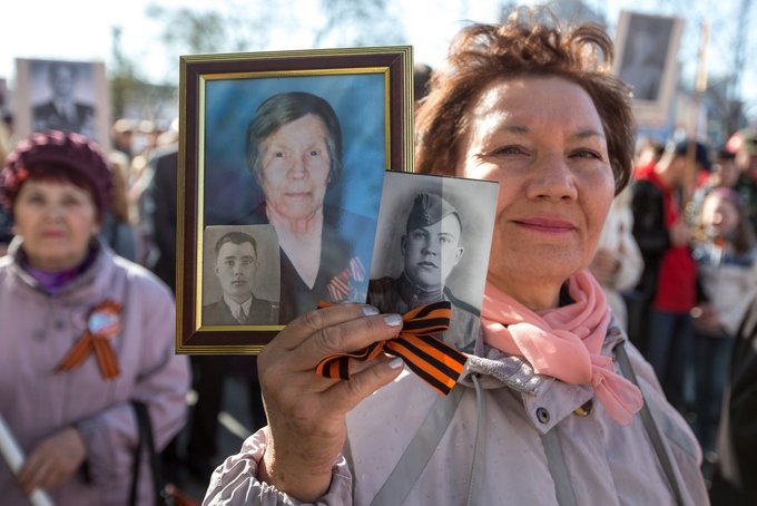 Участники акции «Бессмертный полк» несут фотографии своих родственников-ветеранов