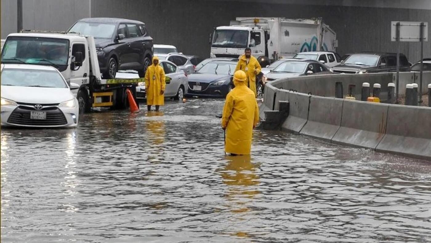 People walk through floodwater following heavy rain in Jeddah, Saudi Arabia on 24 November 2022